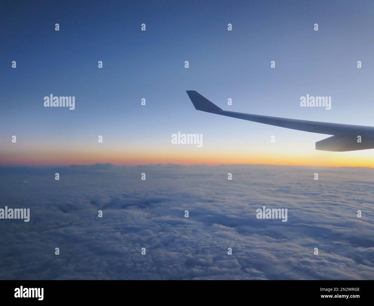 vista del horizonte de la puesta de sol desde el avión, vuelo sobre las nubes Foto de stock