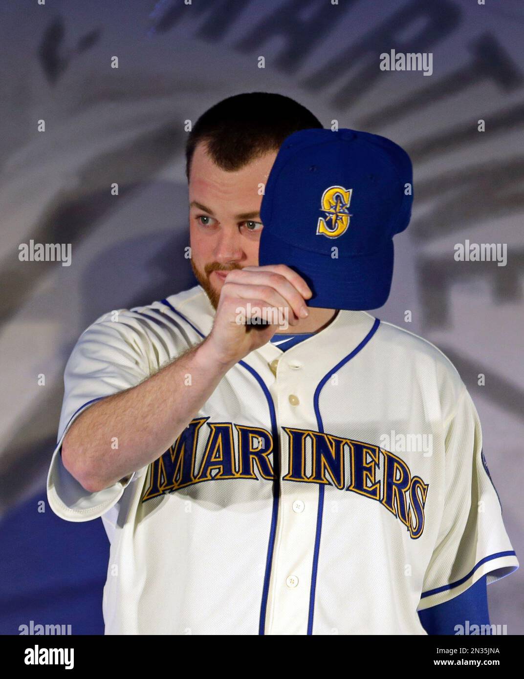 Seattle Mariners' Charlie Furbush displays his cap as the team's new