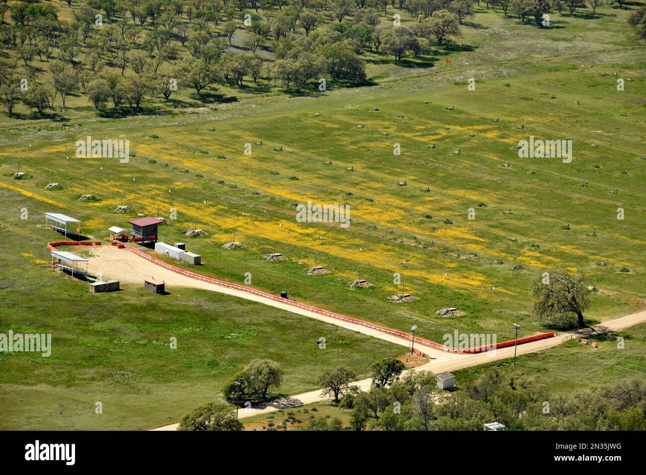 Antenas de Fort Hunter Liggett, California y sus alrededores, 10 de abril de 2019. Rango de tiro con objetivos en el campo de flores amarillas. Foto de stock
