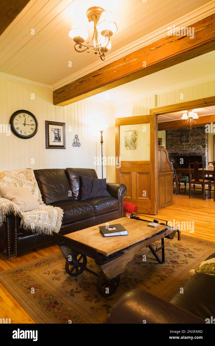 Sala de música con sofás de cuero marrón oscuro y mesa de escala de