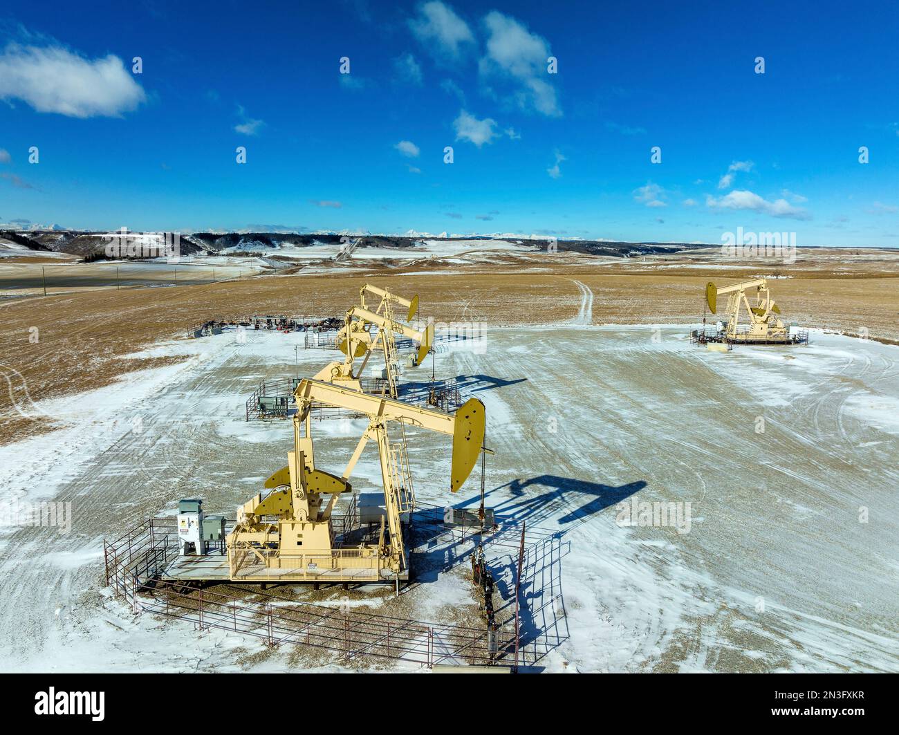 Vista aérea de las calabazas en un campo cubierto de nieve con cielo azul y nubes, al oeste de Airdrie; Alberta, Canadá Foto de stock