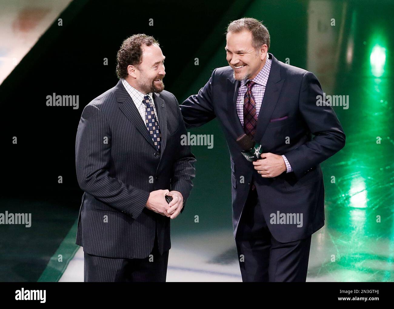 Dallas Stars color commentator Daryl Reaugh, right, greets former