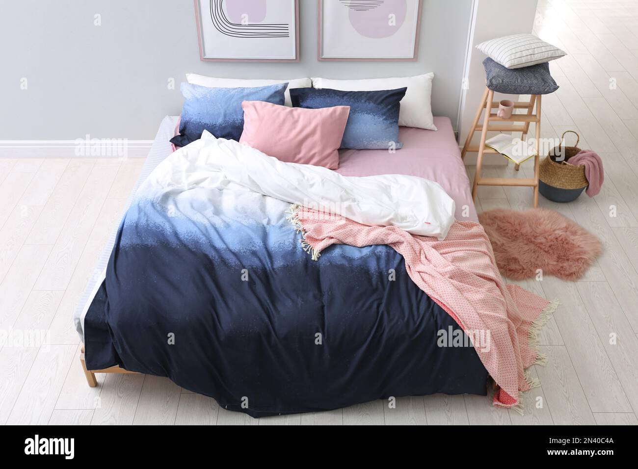 Cama grande con ropa de cama elegante en la habitación, por encima de la vista Foto de stock