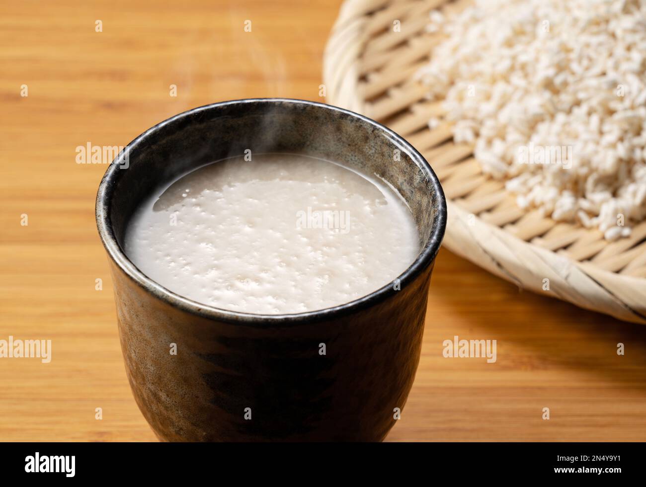 Amazake en la mesa y la malta de arroz en un colador. Amazake es una bebida  dulce tradicional japonesa. Koji es arroz fermentado Fotografía de stock -  Alamy