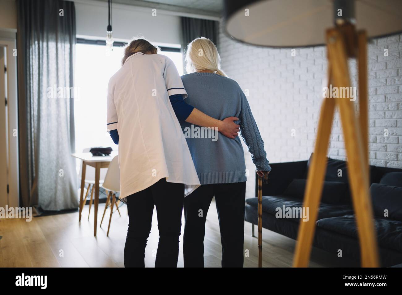 mujer caminando con enfermera de la vejez en casa. Resolución y alta calidad hermosa foto Foto de stock