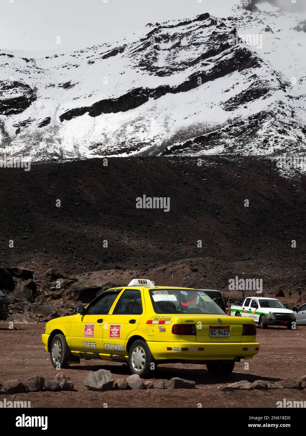 Una imagen que muestra el contraste entre un colorido taxi y el volcán Chimborazo desde Ecuador. Foto de stock