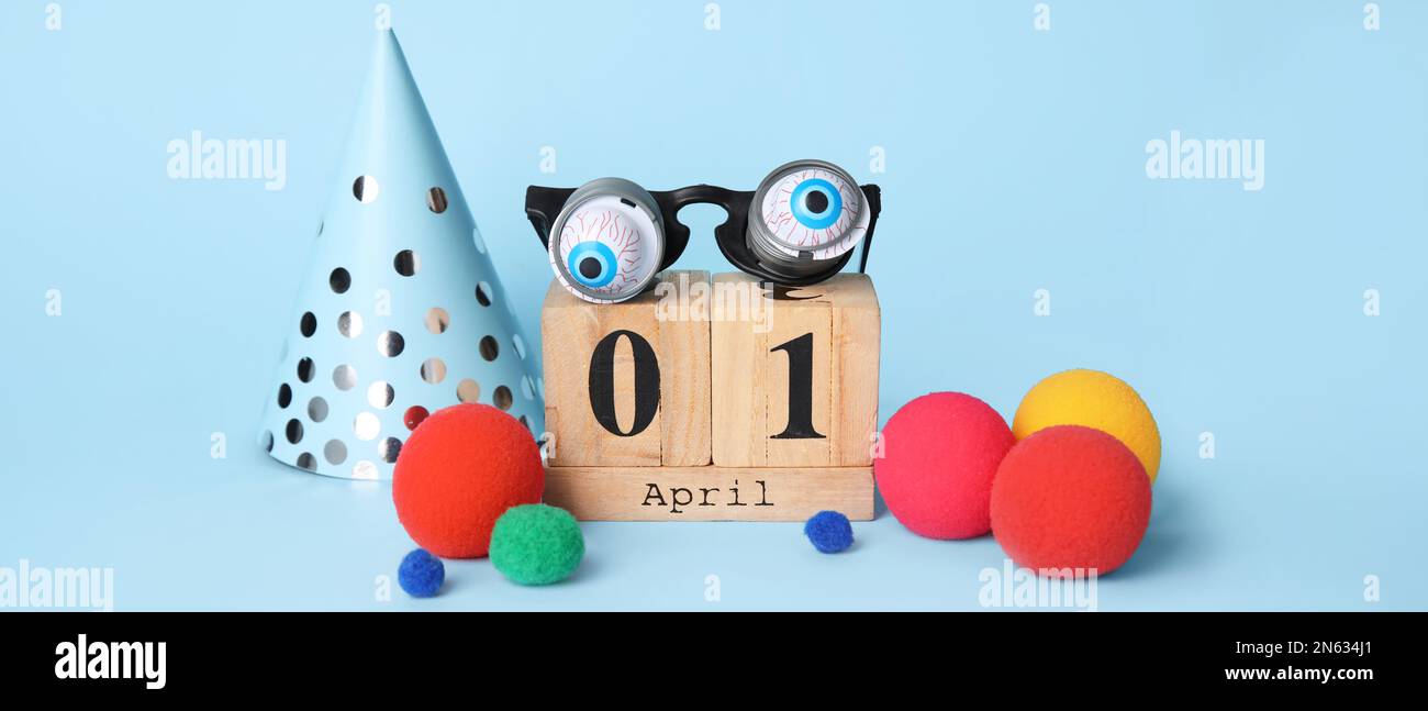 Calendario y decoración del partido para el Día de los Inocentes de abril sobre fondo azul claro Foto de stock