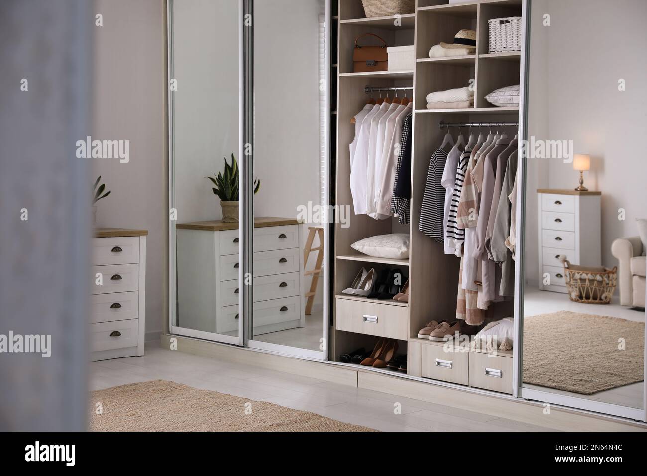 Armario closet con diferentes ropa elegante, zapatos y cosas para el hogar  en la habitación Fotografía de stock - Alamy