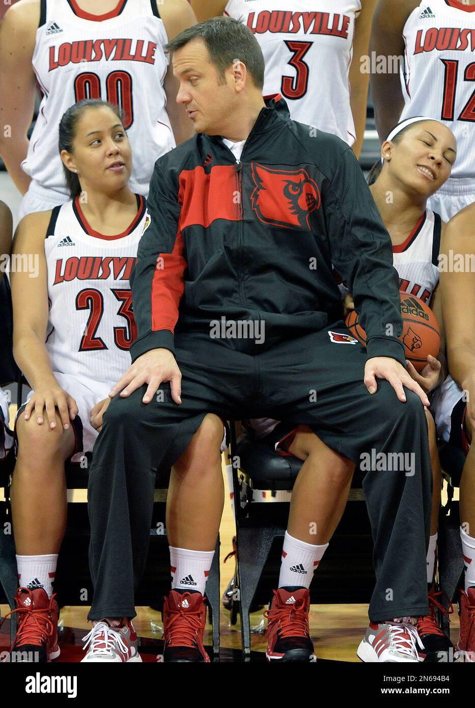 Louisville women's head coach Jeff Walz, center, sits on the laps of