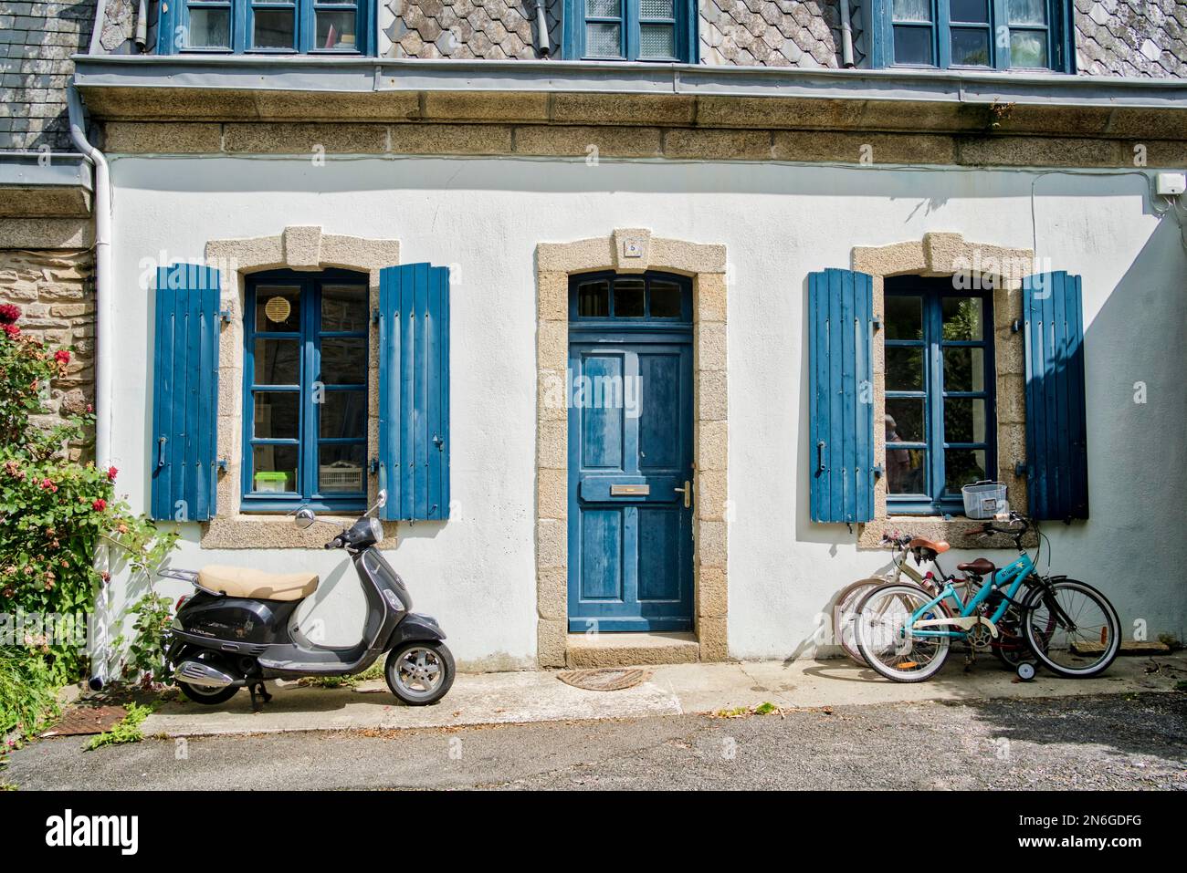 Frente de la casa antigua con bicicleta y scooter, ciclomotor en frente de ella en Ville Close, casco antiguo histórico de Concarneau, Departamento Finistere, Bretaña Foto de stock