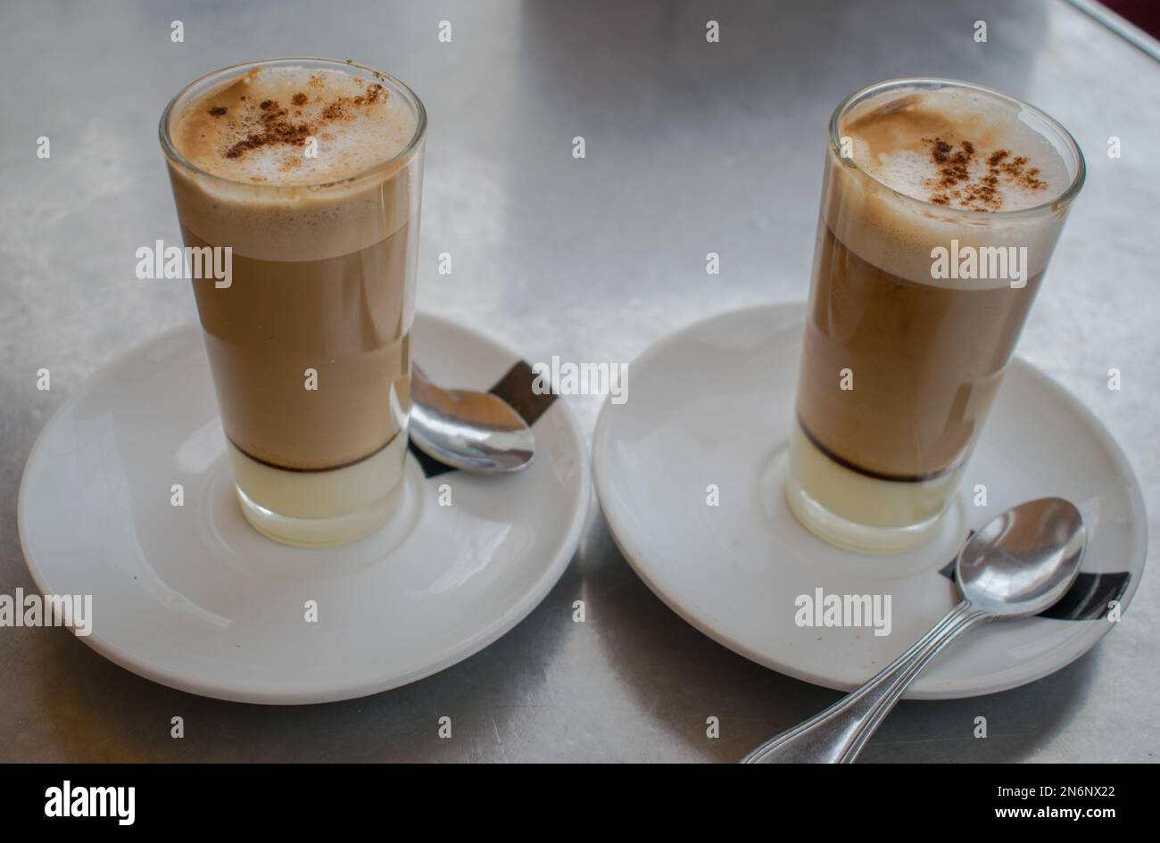 Café con leche en vaso en tabla de metal Foto de stock