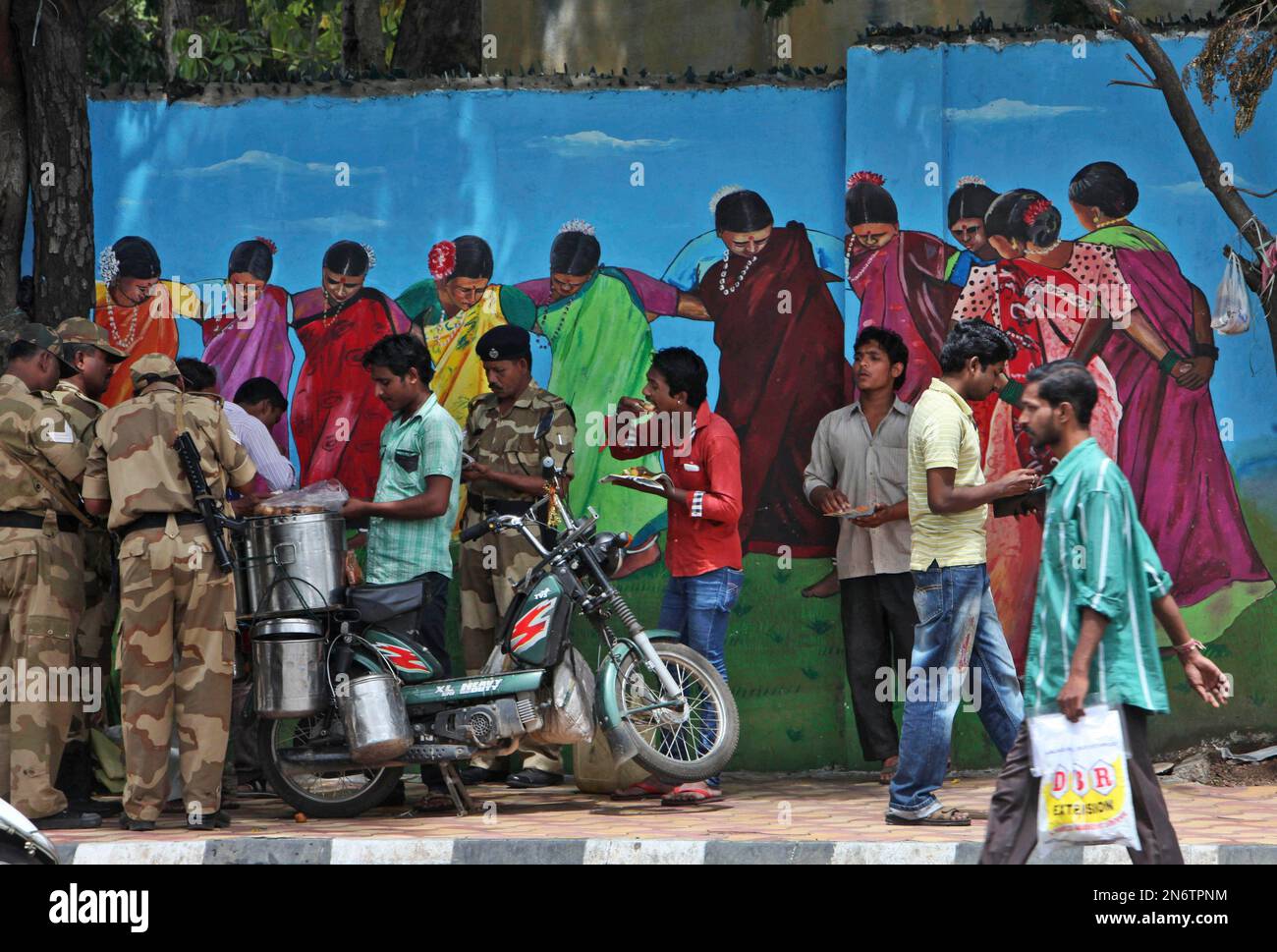 an-indian-man-sells-food-on-a-two-wheeler-to-security-men-and-others-on