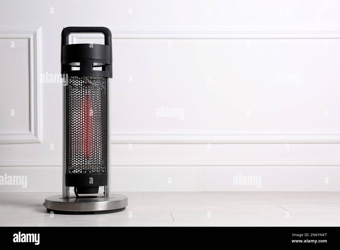 Nuevo calentador eléctrico moderno en el piso en habitación, espacio para el texto Fotografía de stock - Alamy