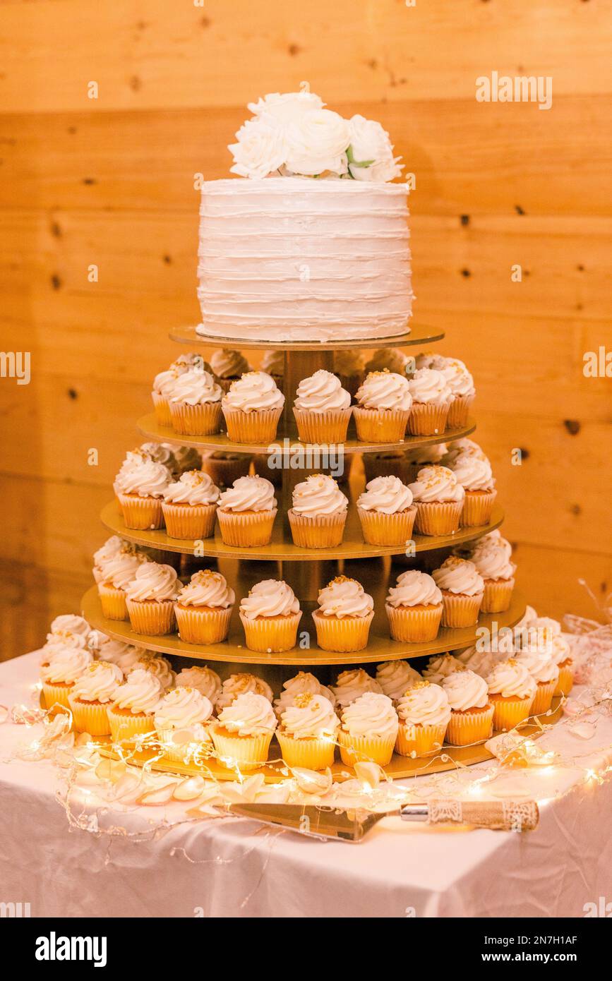 Un tiro vertical de cupcakes en forma de pastel con un pastel de bodas  blanco en la parte superior Fotografía de stock - Alamy