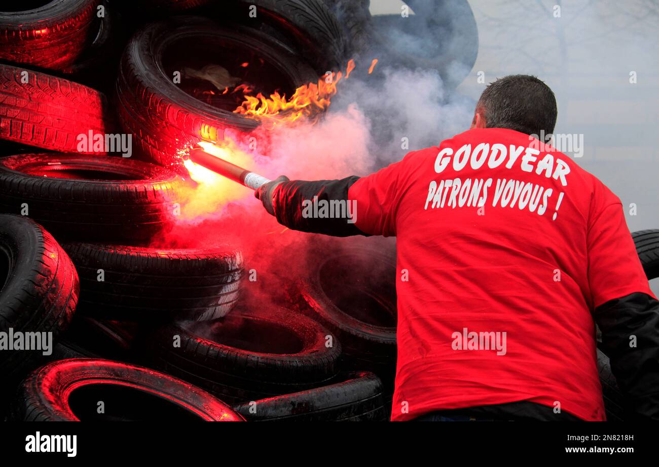 Goodyear employee burns tires, outside the Goodyear tyre company, in