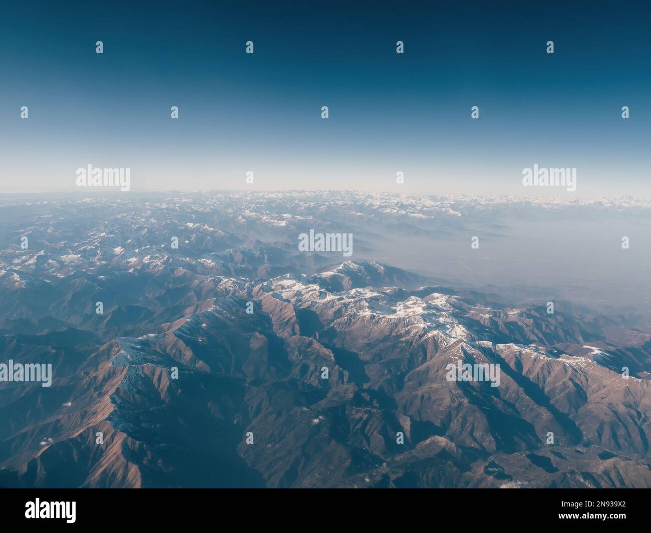 Increíblemente hermosa vista aérea panorámica de las cadenas montañosas  cubiertas de nieve de los Alpes. Vuelo sobre los picos de las montañas  alpinas cubiertas de nieve en algunos lugares Fotografía de stock -