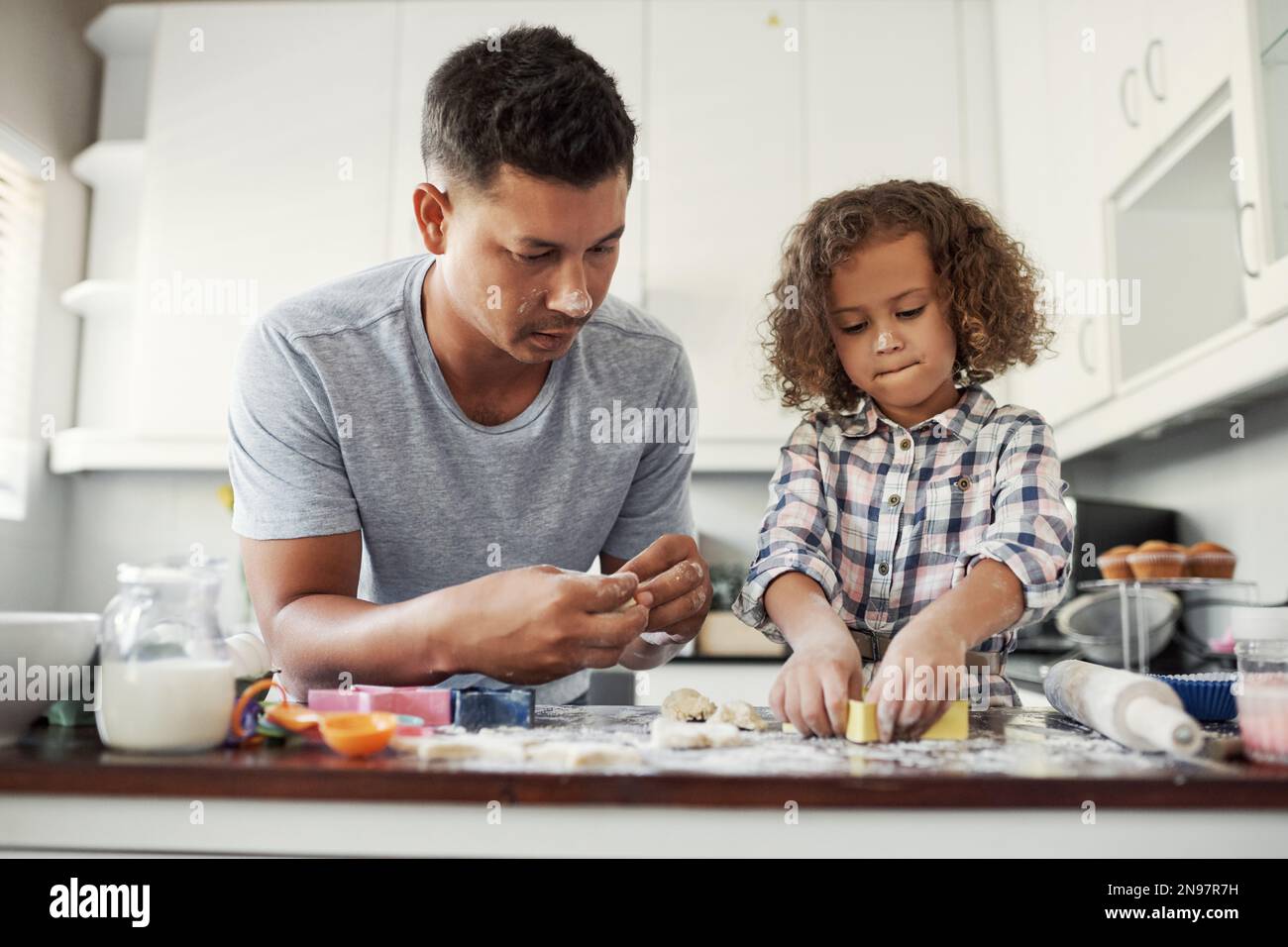 Papá salva la masa. una niña dulce horneando con su padre en casa en la  cocina Fotografía de stock - Alamy
