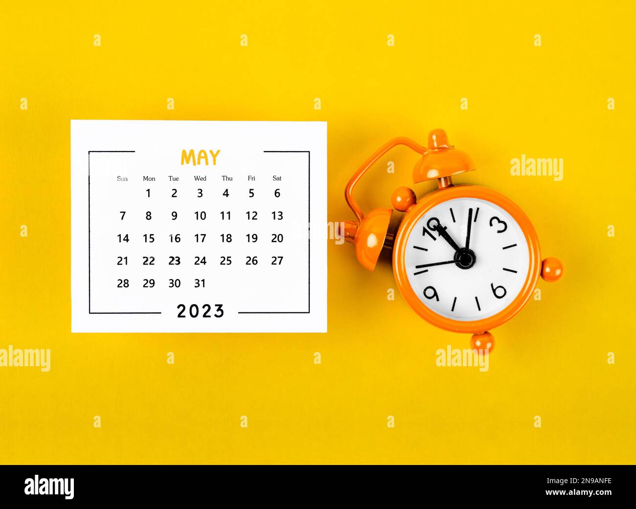 Un calendario mensual de mayo de 2023 para que el organizador planifique  2023 año con reloj despertador sobre fondo amarillo Fotografía de stock -  Alamy