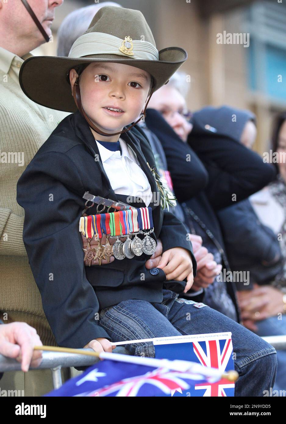 A young boy wearing the medals of a veteran watches the annual ANZAC Day parade in Sydney