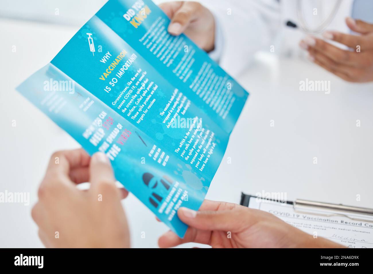 He puesto toda la información importante aquí. un médico irreconocible sentado con su paciente y mostrándole un folleto durante una consulta. Foto de stock