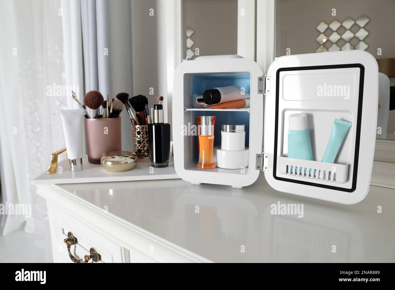 Mini nevera para productos cosméticos en la mesa de tocador blanca  Fotografía de stock - Alamy