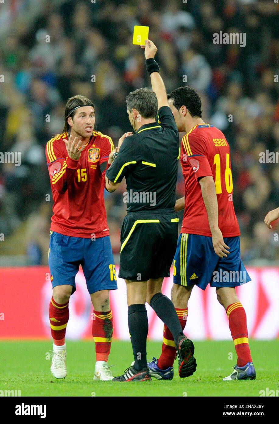 Spain's Sergio Ramos, left, receives a yellow card from referee Belgium