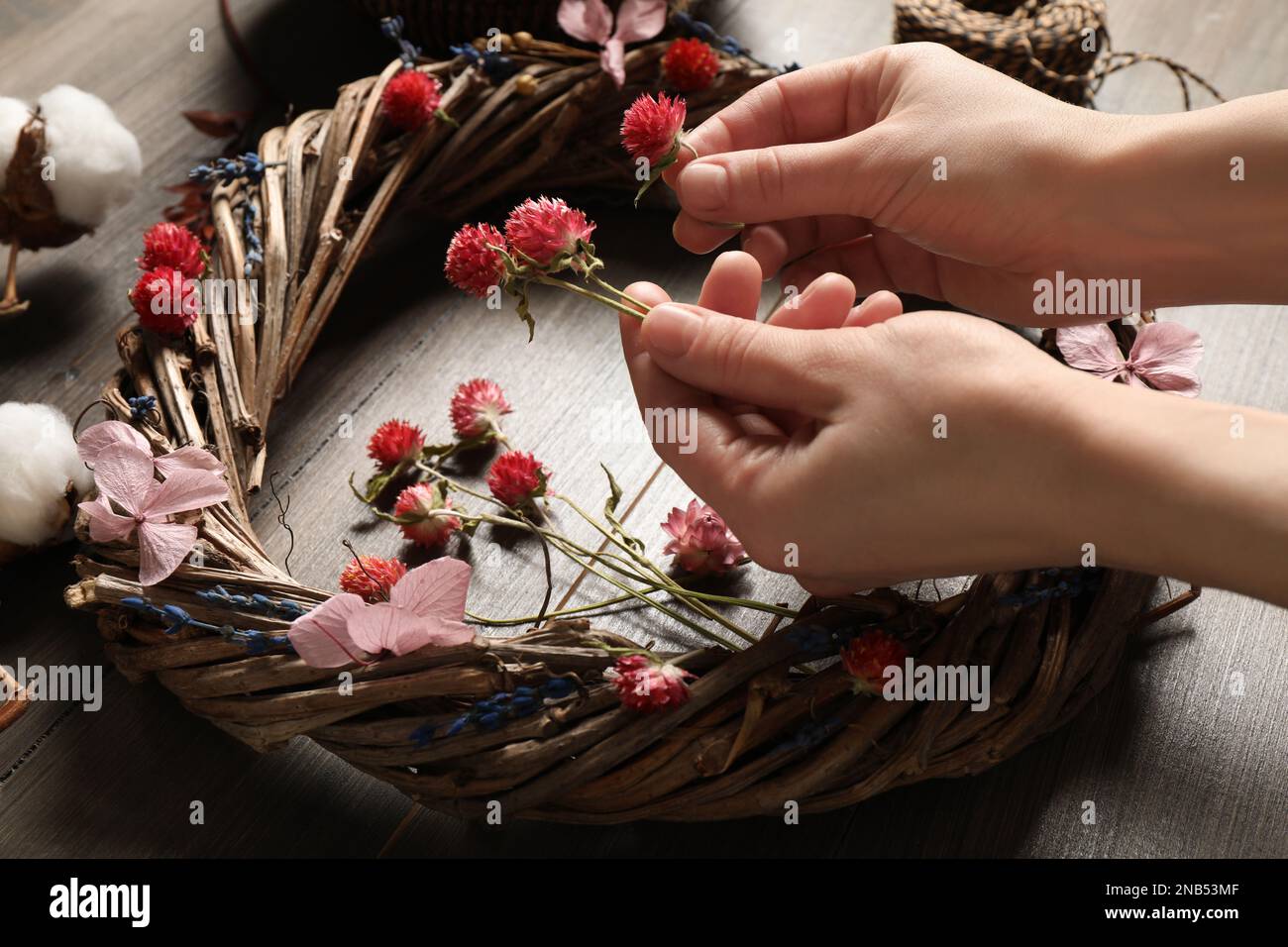 Florista haciendo guirnalda con flores secas en la mesa de madera, primer  plano Fotografía de stock - Alamy