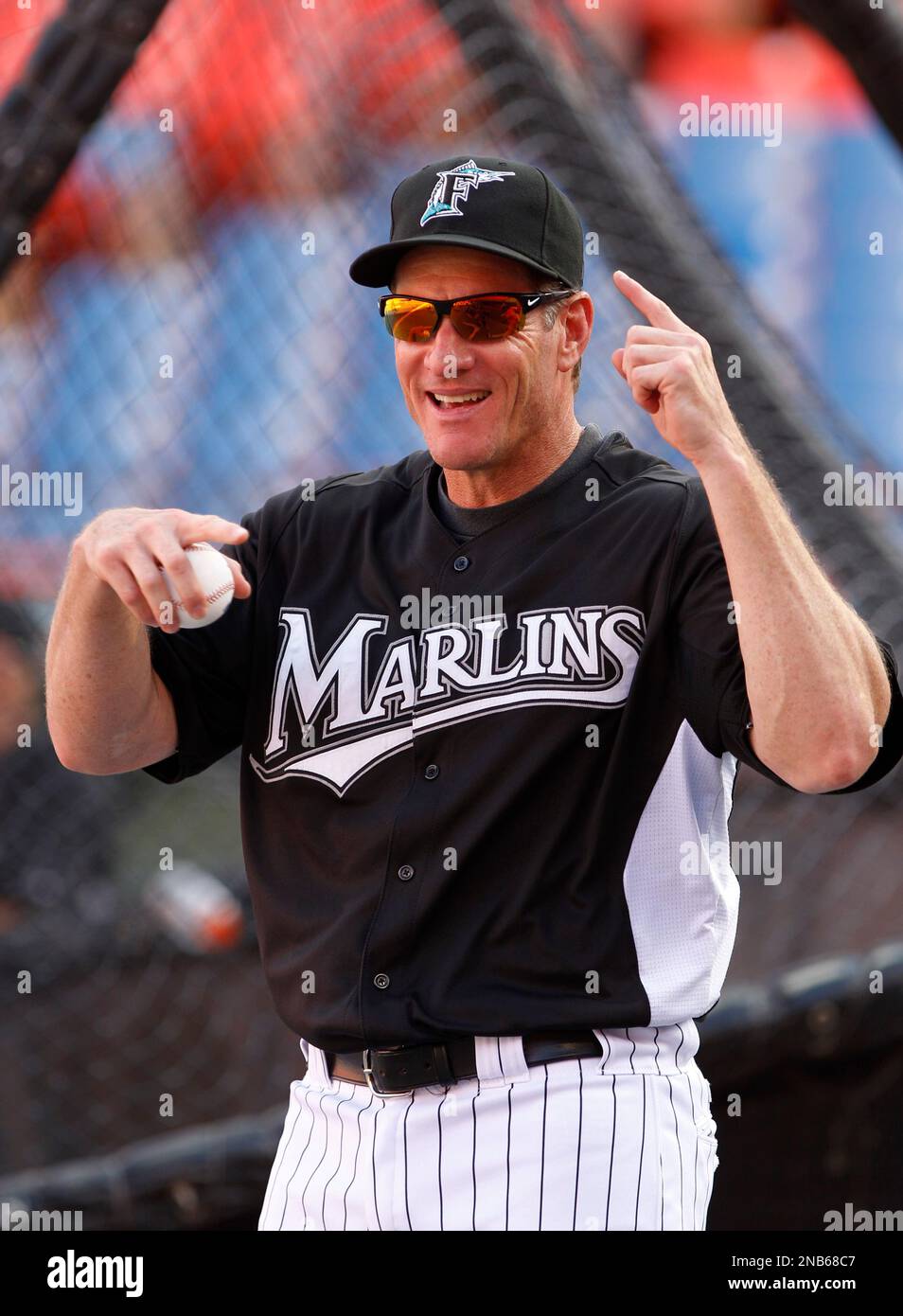 Former Miami Marlins player Jeff Conine, center, holds a jersey from 2017  as he speaks to fans with former players Luis Aquino, left, and Gaby  Sanchez, right, during a Miami Marlins baseball