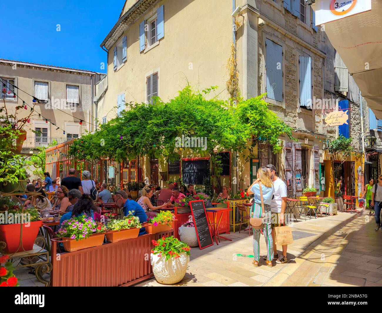 Un colorido callejón de tiendas y cafés en el centro histórico medieval de Saint-Rémy de Provence. Foto de stock
