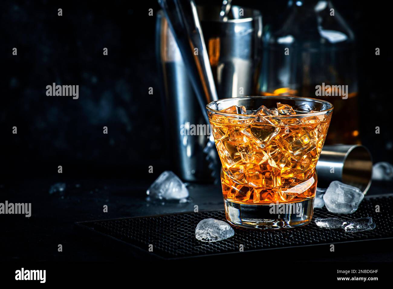 escribir haz Irregularidades Cóctel alcohólico padrino con whisky escocés, licor de amaretto y hielo.  Fondo de barra negra, herramientas de barra de acero, espacio de copia  Fotografía de stock - Alamy