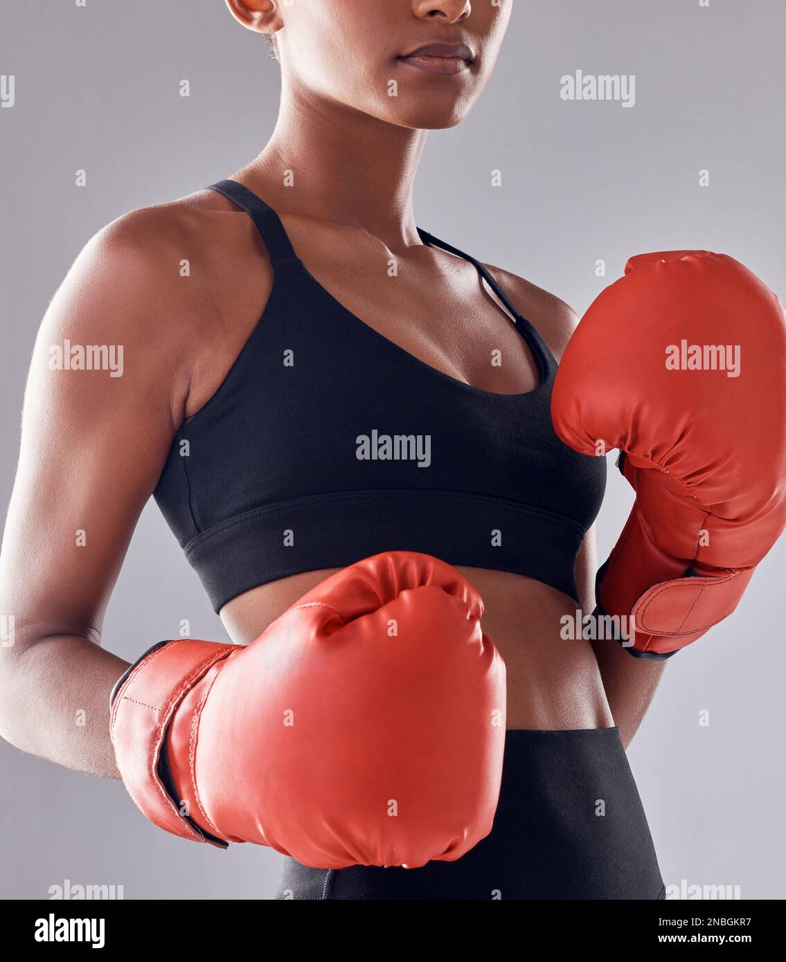 Boxeo, guantes de fitness y mujer en estudio para el ejercicio deportivo, músculo fuerte o entrenamiento mma. Boxeador femenino, entrenamiento y puño lucha por el impacto, la energía Foto de stock