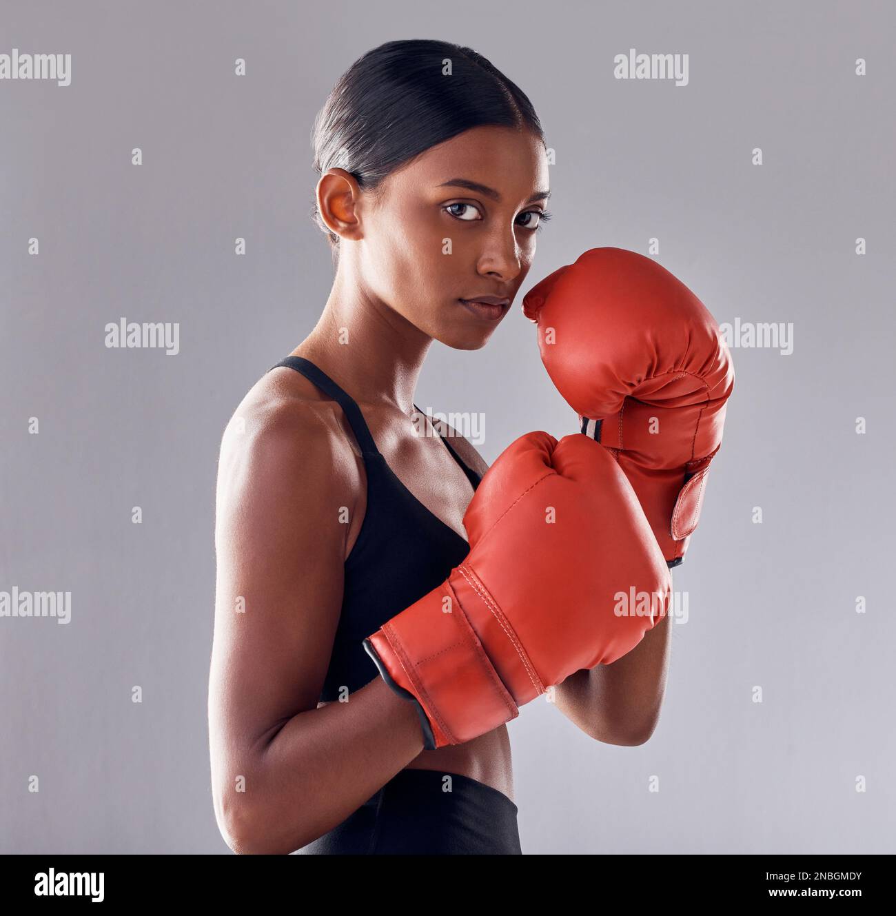 Boxeo, guantes y retrato de mujer en estudio para ejercicio deportivo, musculatura fuerte o entrenamiento mma. Boxeador femenino indio, entrenamiento y lucha por el puño Foto de stock