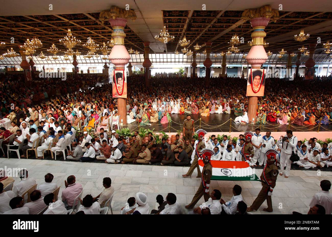Policemen carry an Indian flag to be placed on the casket containing