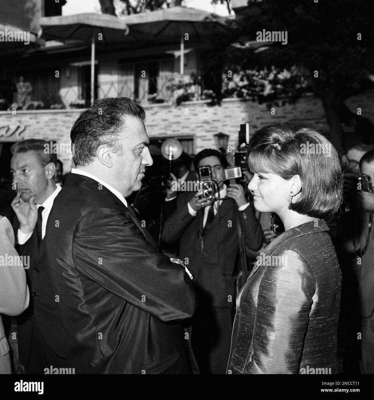 Italian actress Claudia Cardinale and Italian movie director Federico Fellini are shown during the symbolic ceremony of the Oscar Academy Award given to Federico Fellini for his film “Eight And A Half” in a Rome, Italy, theater on May 26, 1964. Italian Premier Aldo Moro handed the statuette to Fellini during the ceremony, arranged so that Italian cinema personalities and Government officials could demonstrate their appreciation of Fellini’s achievement in winning the Award. Fellini was present in Santa Monica, California on April 14, to receive his statuette for the best foreign film. (AP Phot Foto de stock