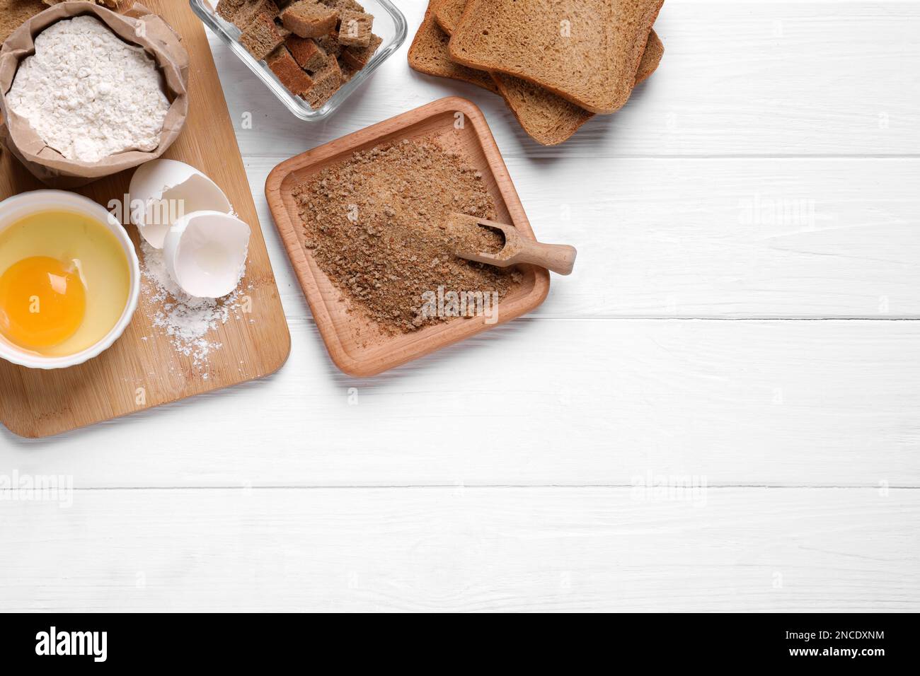 Pan rallado fresco, harina y huevo en la mesa de madera blanca, plana.  Espacio para texto Fotografía de stock - Alamy