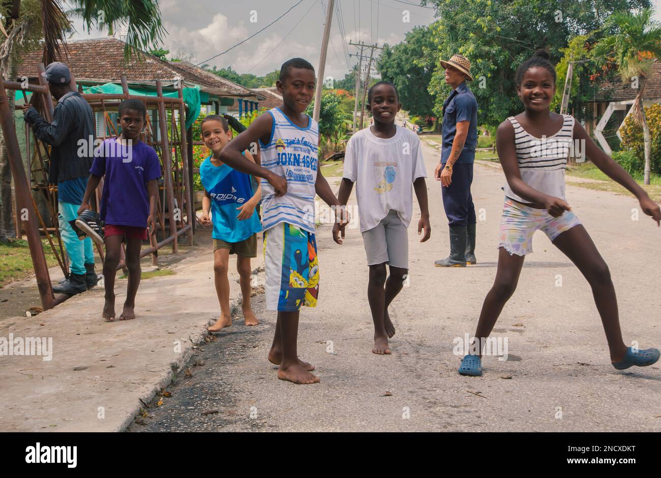 Augusto César Sandino, Artemisa, Cuba. 12th de julio de 2019. Grupo de niños de una ciudad rural jugando en medio de la calle y sonriendo. Foto de stock