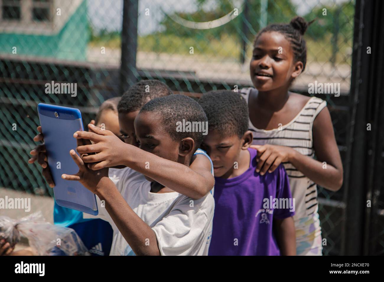 Augusto César Sandino, Artemisa, Cuba. 12th de julio de 2019. Grupo de niños y una niña jugando con una tableta en un pueblo rural de Cuba. Foto de stock