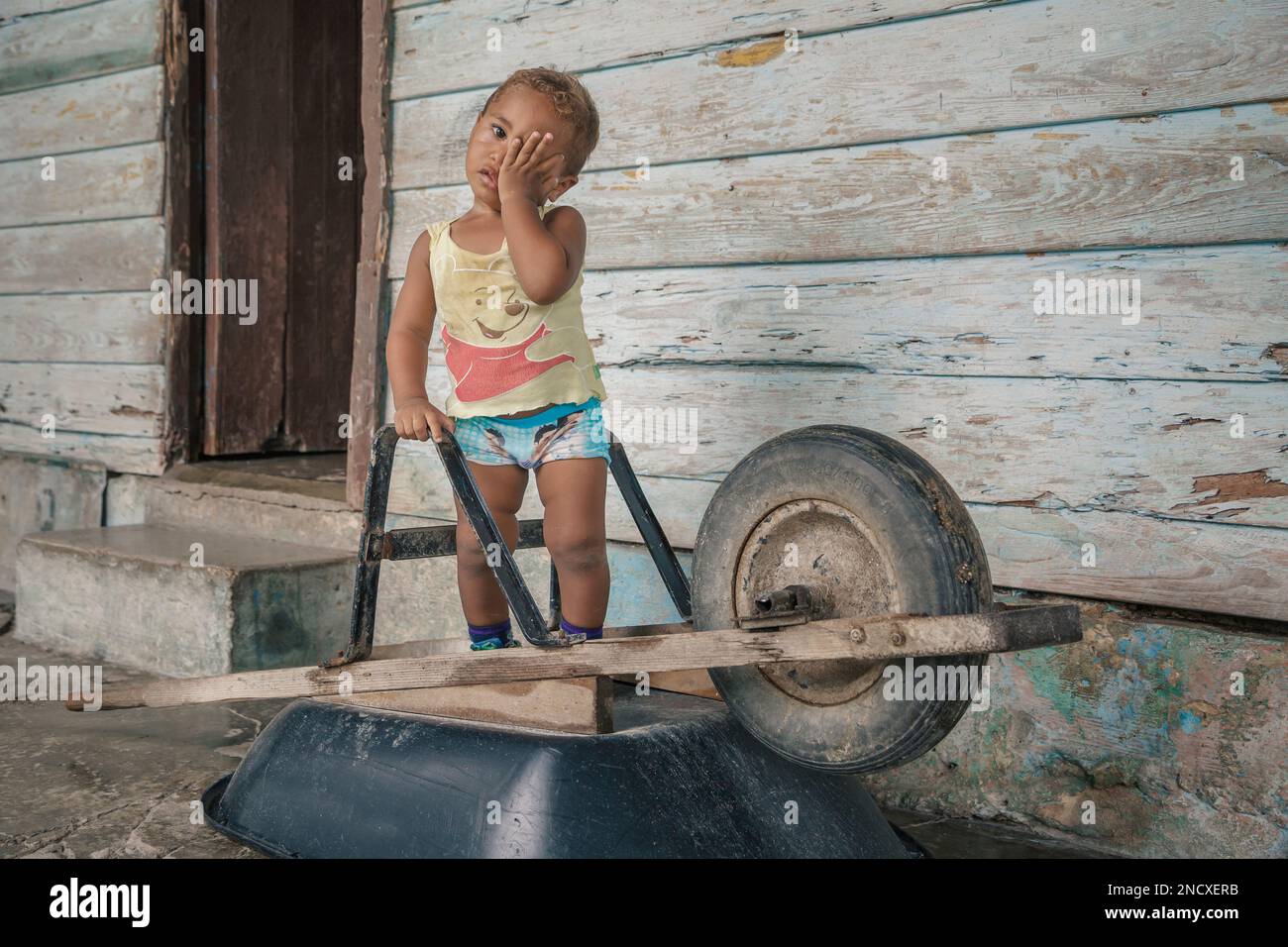 Augusto César Sandino, Artemisa, Cuba. 11th de julio de 2019. Niño jugando con una carretilla en la puerta de su casa ubicada en un pueblo rural, Cuba. Foto de stock