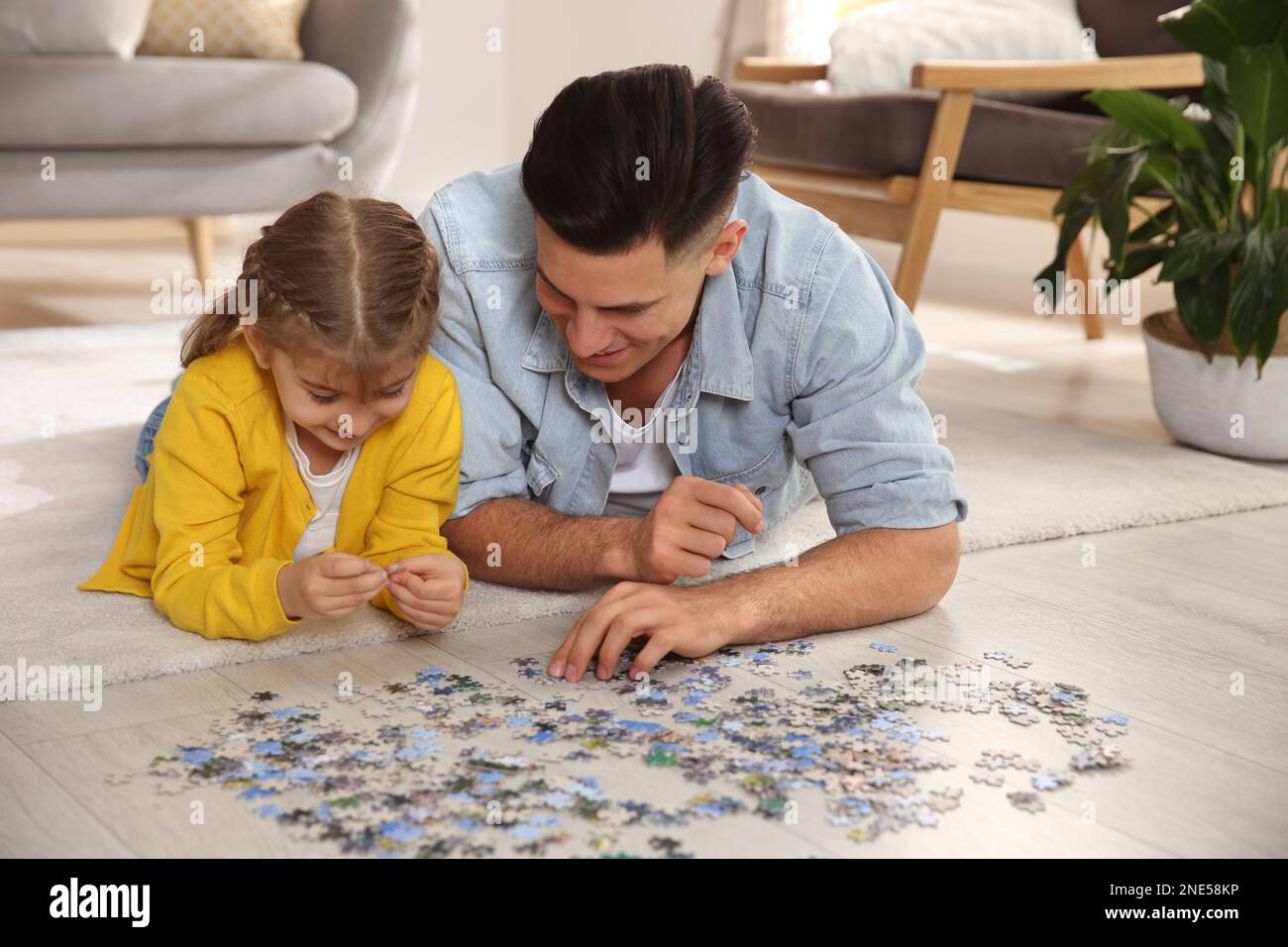 Padre feliz y su hija jugando con rompecabezas en el piso en casa  Fotografía de stock - Alamy