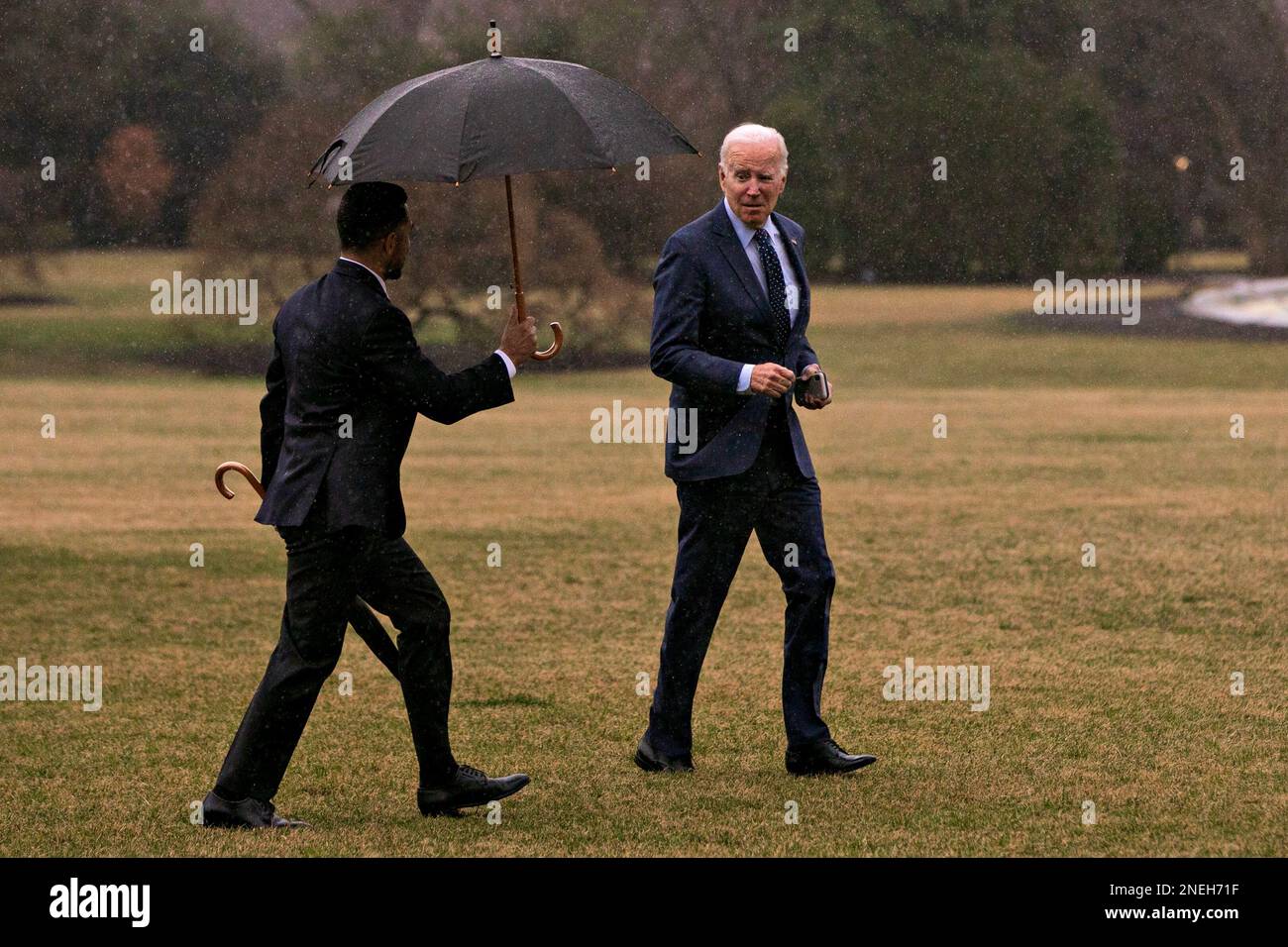 El presidente ESTADOUNIDENSE Joe Biden recibe un paraguas después de llegar  al South Lawn de la Casa Blanca desde Marine One en Washington, DC, EE.UU.,  el jueves 16 de febrero, 2023.- Biden
