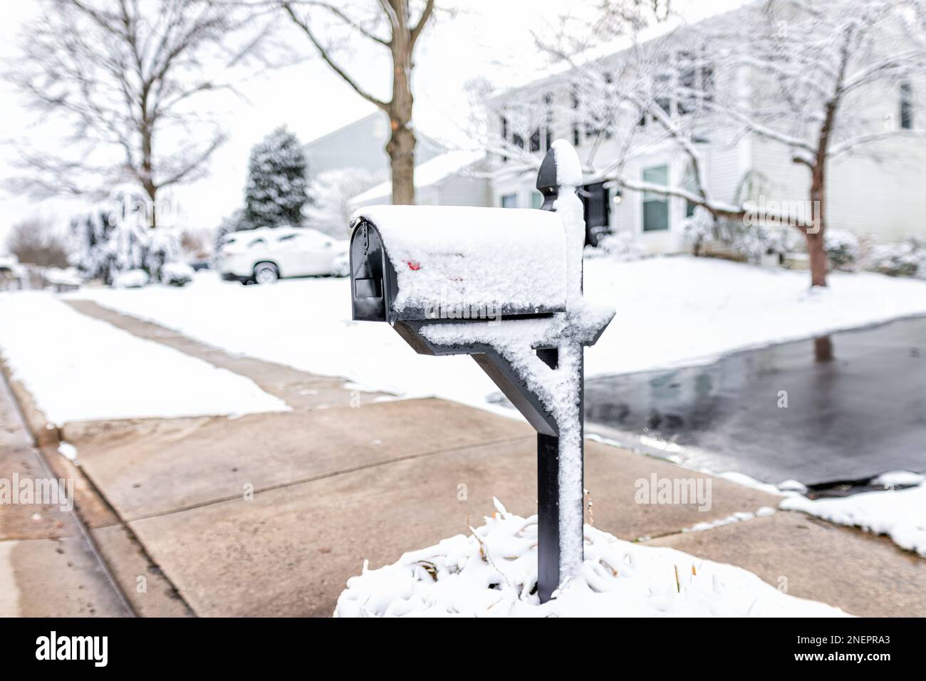 Buzón cubierto de nieve blanca en la calle de la acera en los suburbios del norte de Virginia y casa unifamiliar en el área metropolitana de Washington DC en la temporada de invierno weathe Foto de stock