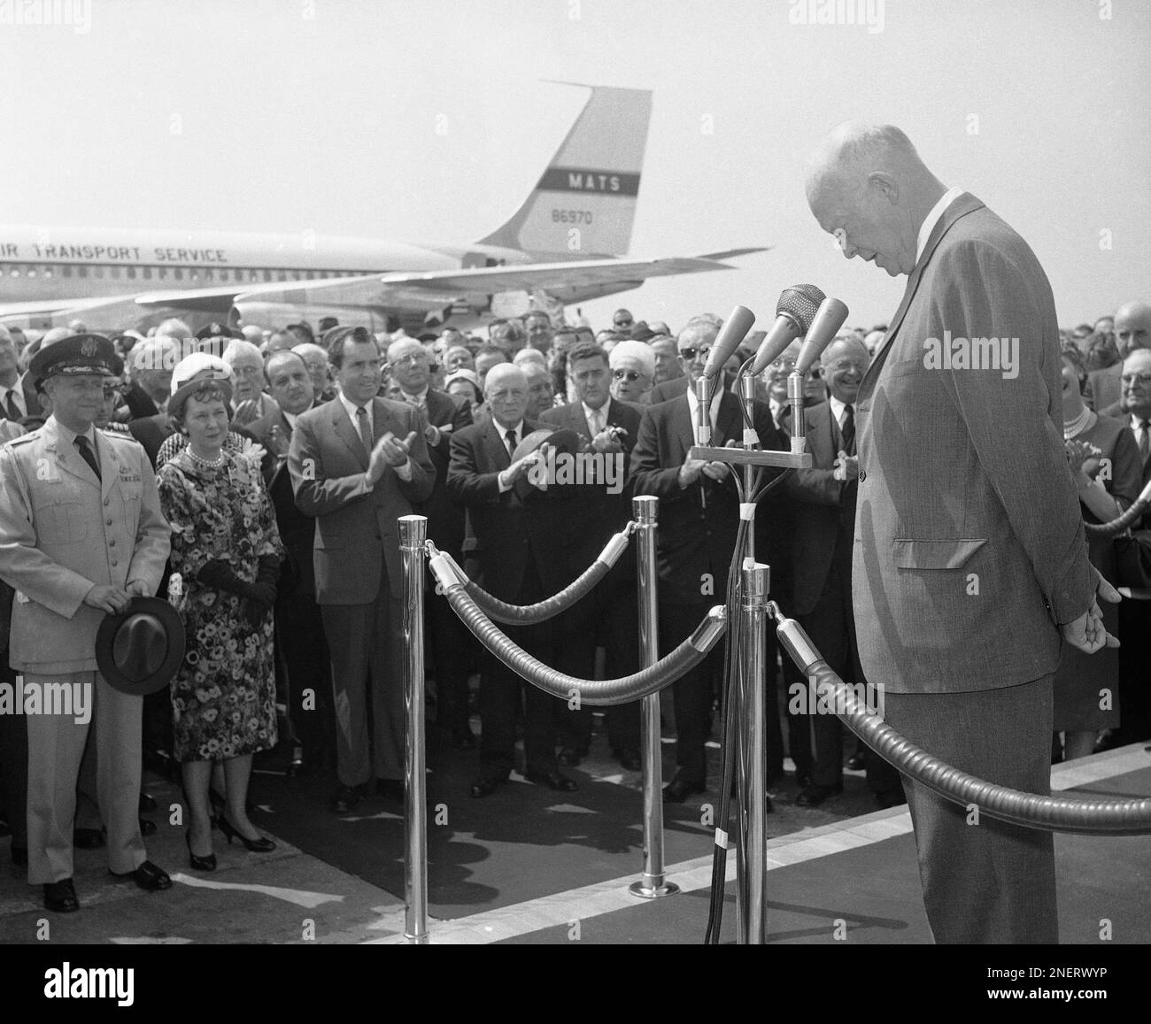 President Dwight Eisenhower bows his head to applause from throng which