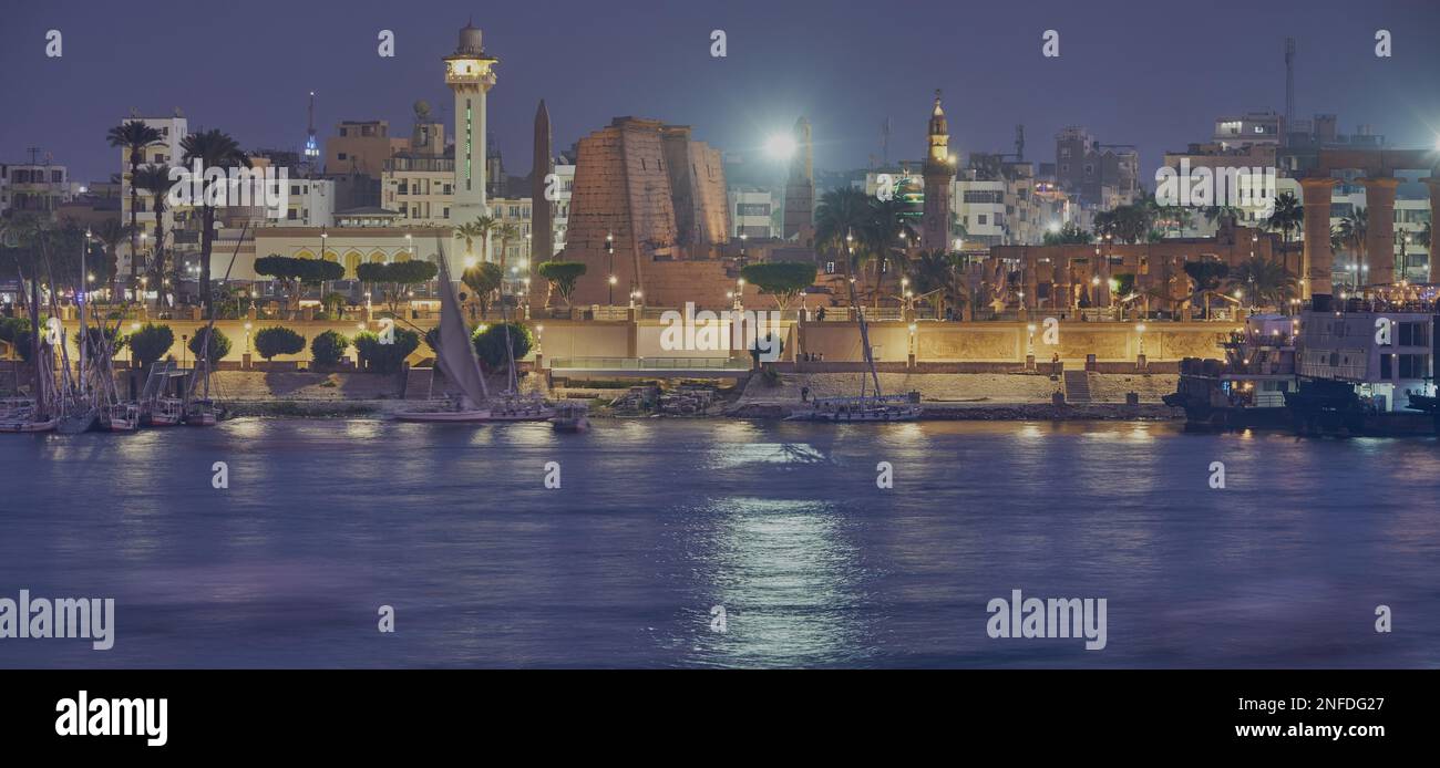 Luxor, Egipto foto de la noche desde la orilla oeste que muestra el río Nilo con Feluccas y el templo de Luxor en la orilla este Foto de stock