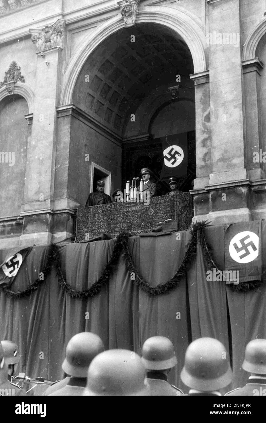German Chancellor Adolf Hitler speaks into microphones on the balcony