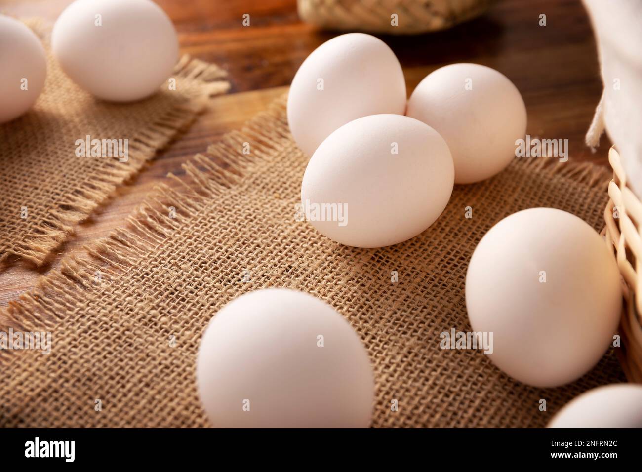 Muchos huevos de pollo blanco en la mesa de madera rústica. Producto alimenticio nutritivo y económico muy popular. Imagen de primer plano. Foto de stock