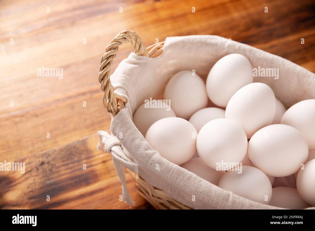 Muchos huevos de pollo blanco en la mesa de madera rústica. Producto alimenticio nutritivo y económico muy popular. Imagen de cierre con espacio de copia. Foto de stock