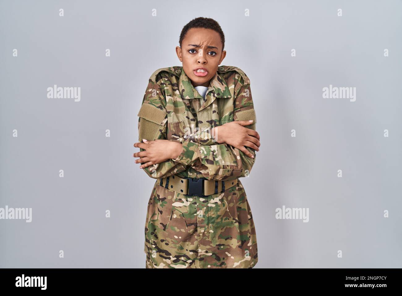 Hermosa mujer afroamericana que lleva uniforme del ejército del camuflaje  temblando y congelado para el frío del invierno con expresión triste y de  choque en la cara Fotografía de stock - Alamy