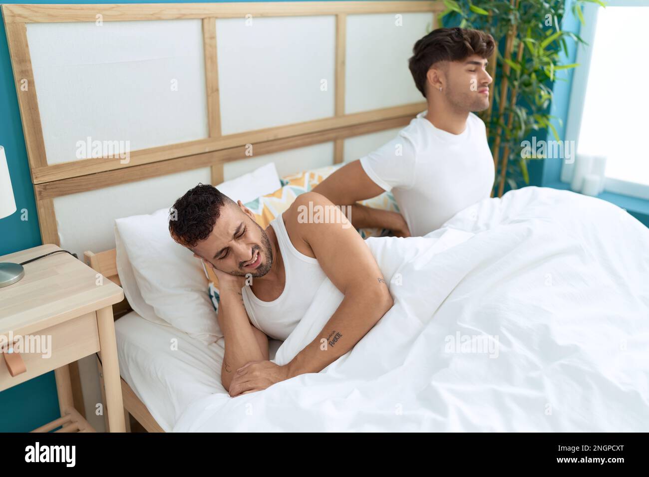 Dos parejas de hombres hispanos que sufren de lesiones en la espalda sentados en la cama en el dormitorio Fotografía de stock - Alamy Dos parejas de hombres hispanos que sufren de lesiones en la espalda sentados en la cama en el dormitorio Fotografía de stock - Alamy