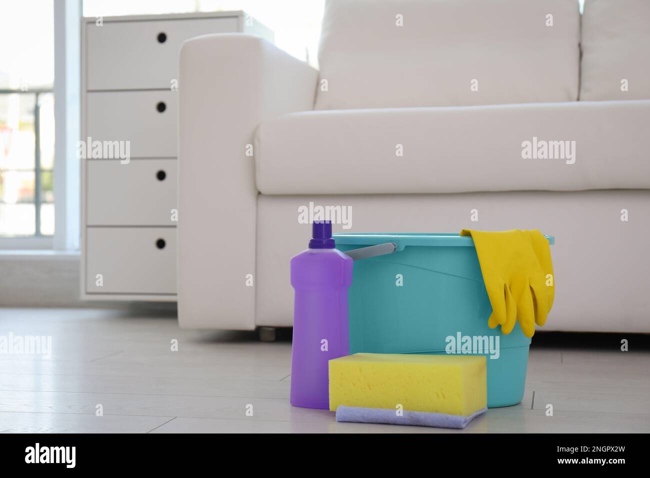 Cubeta azul para la limpieza con guantes amarillos y una variedad de  detergentes con trapos. Limpieza de la habitación.Cubo con artículos de  limpieza sobre fondo claro Fotografía de stock - Alamy