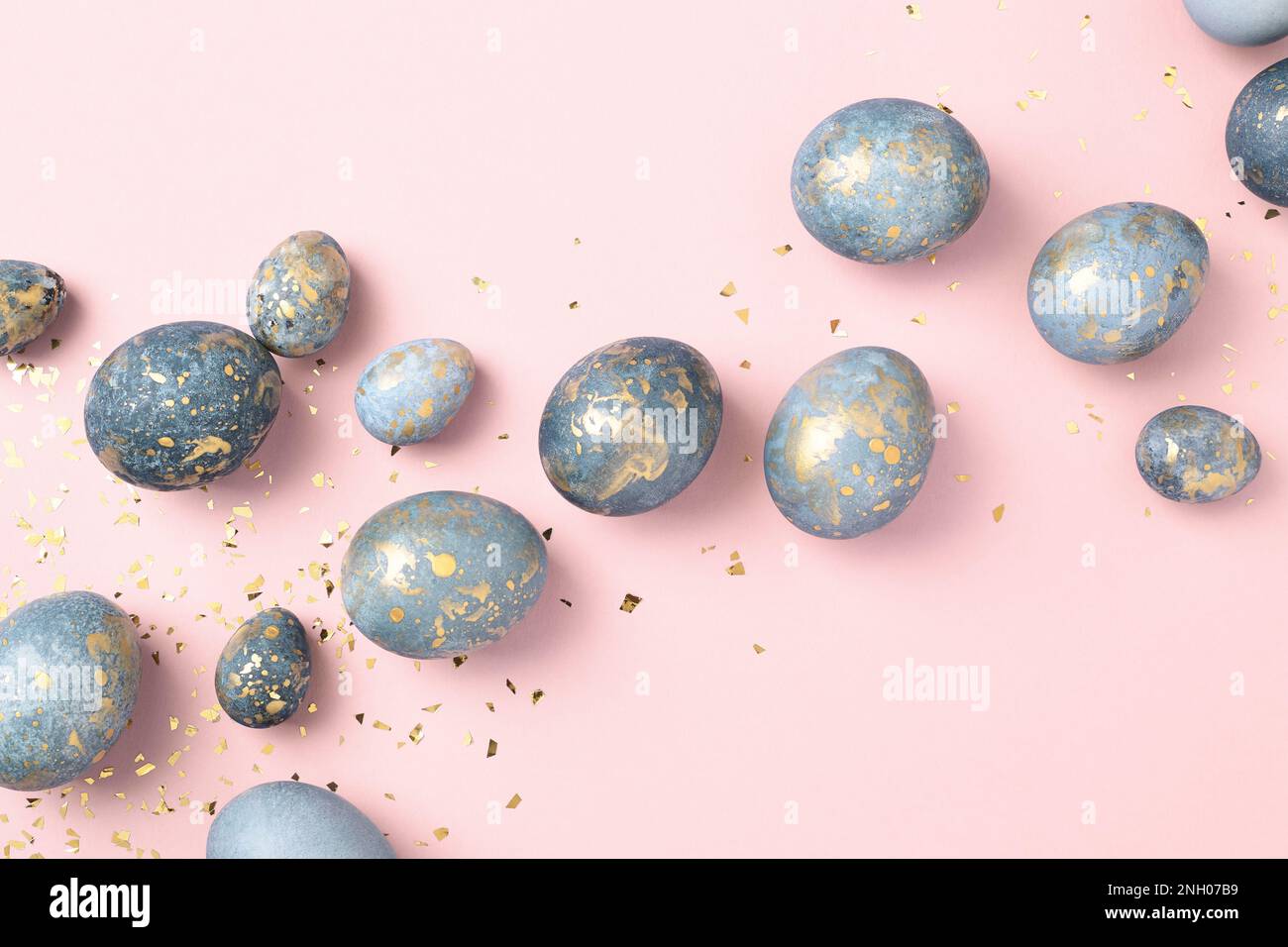 Huevos de Pascua azules sobre fondo rosa con confeti de oro. Tarjeta de felicitación chic de Pascua. Celebración de Pascua. Foto de stock